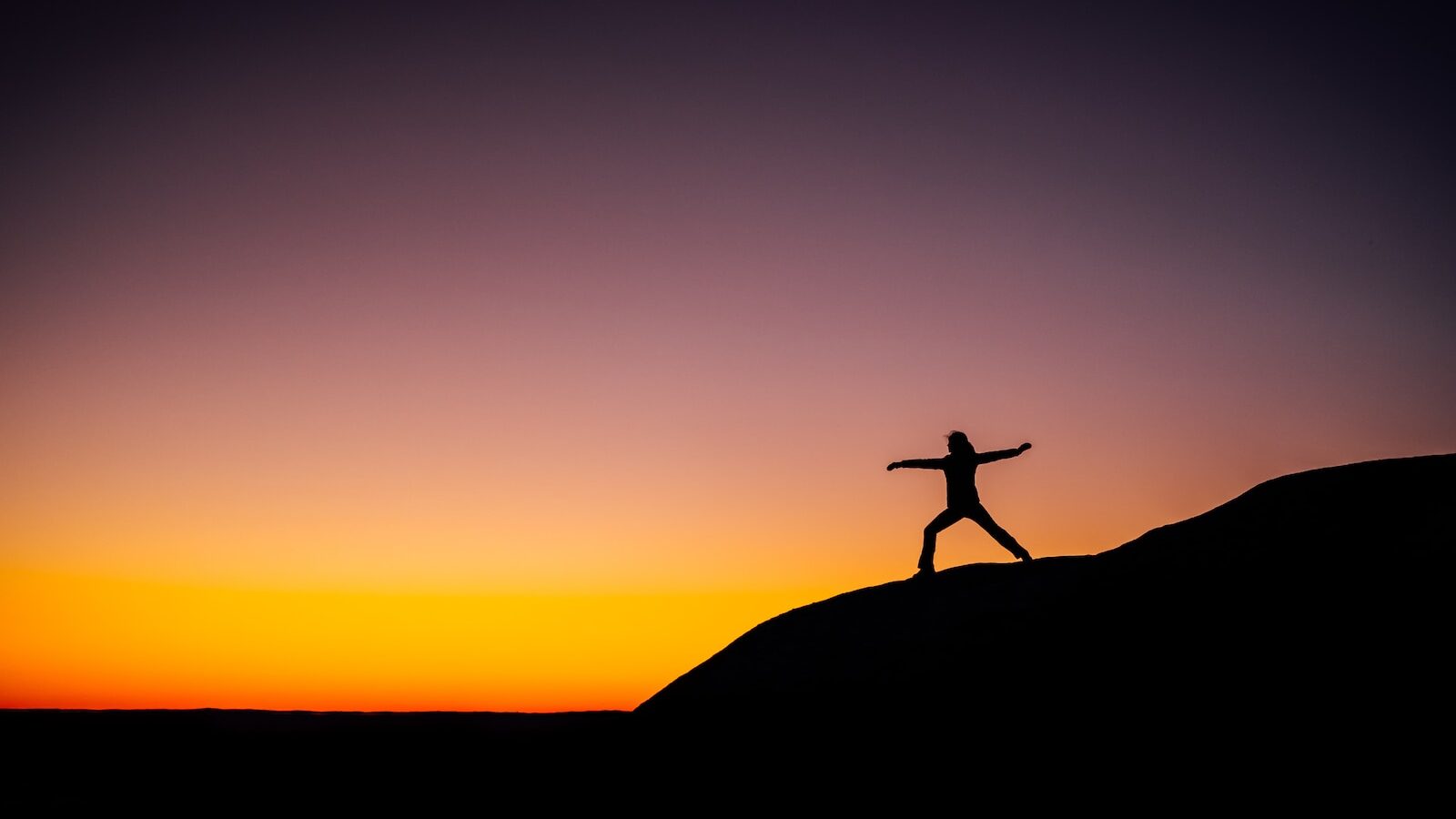 shillouette photo of person standing at the peak