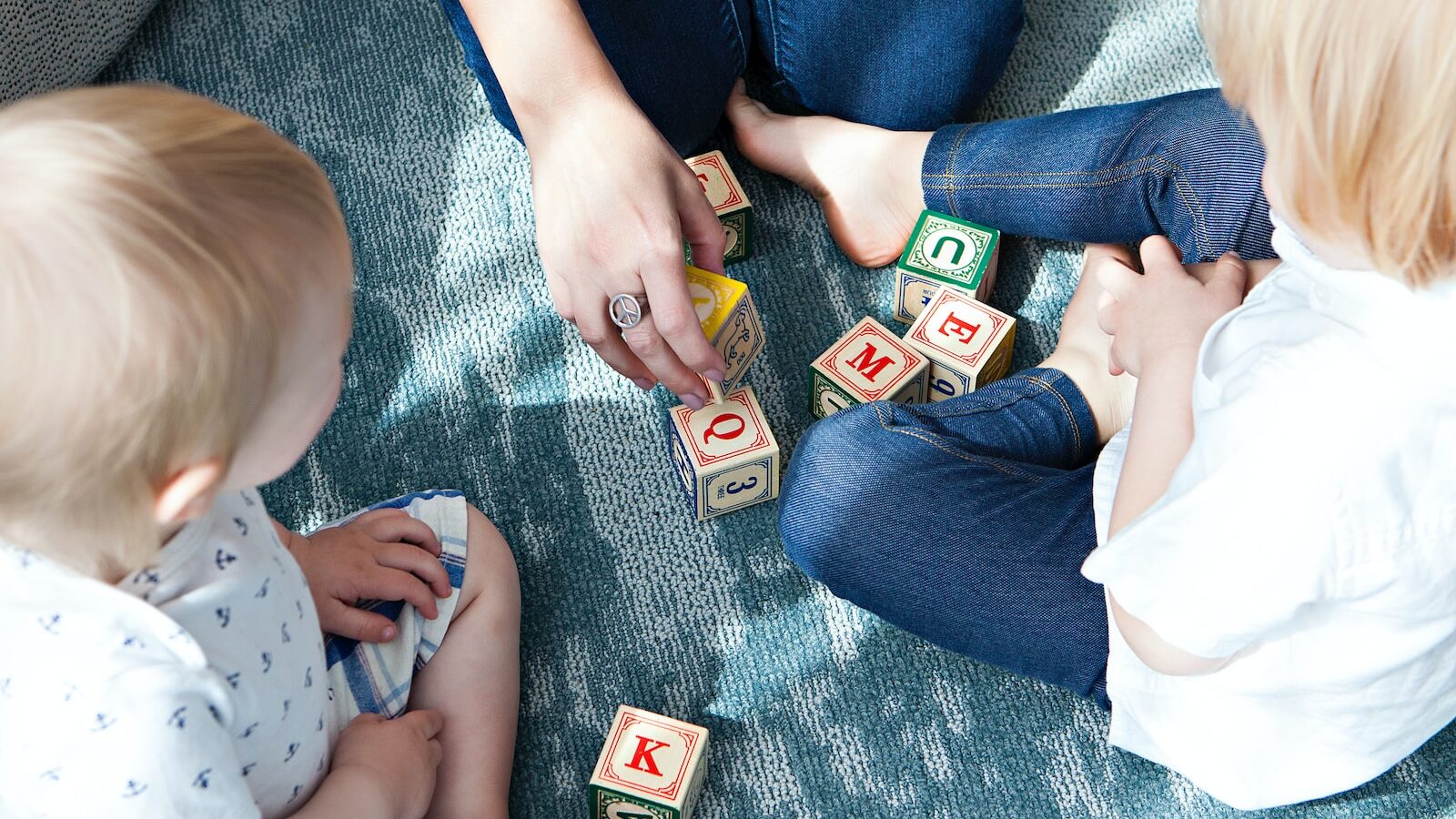 two toddler playing letter cubes