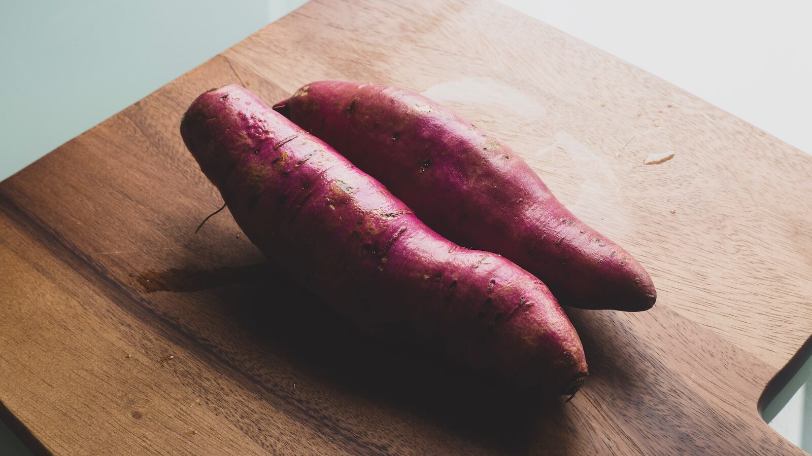 two red sausage on brown wooden chopping board