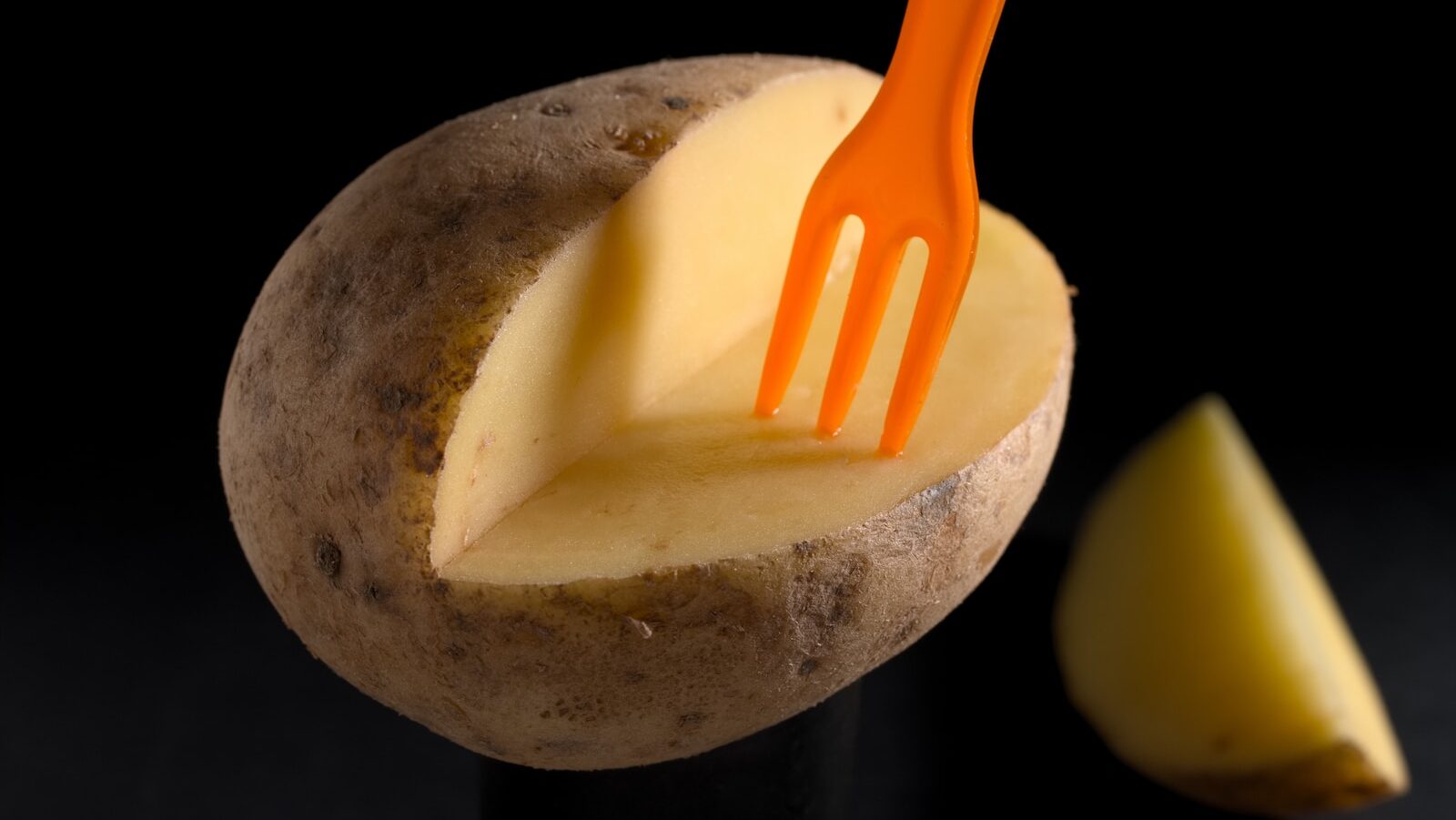 orange plastic fork on brown potato