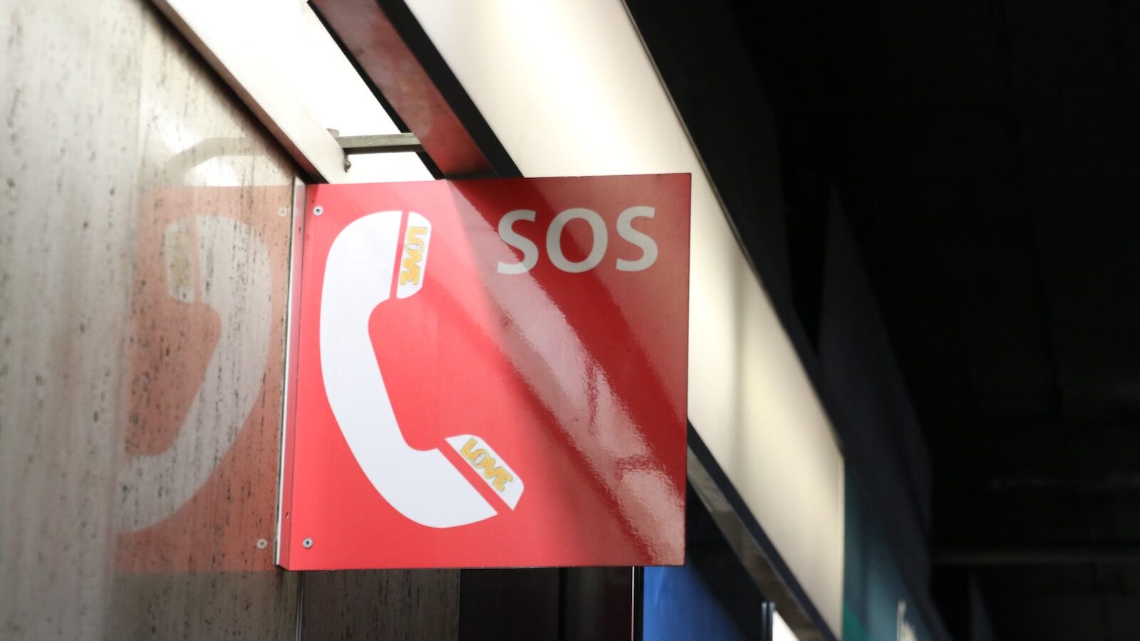 a red sign hanging from the side of a building